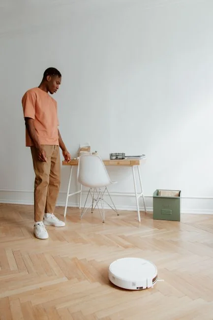 Side view of young ethnic male in uniform cleaning floor with mop while working in retro styled restaurant